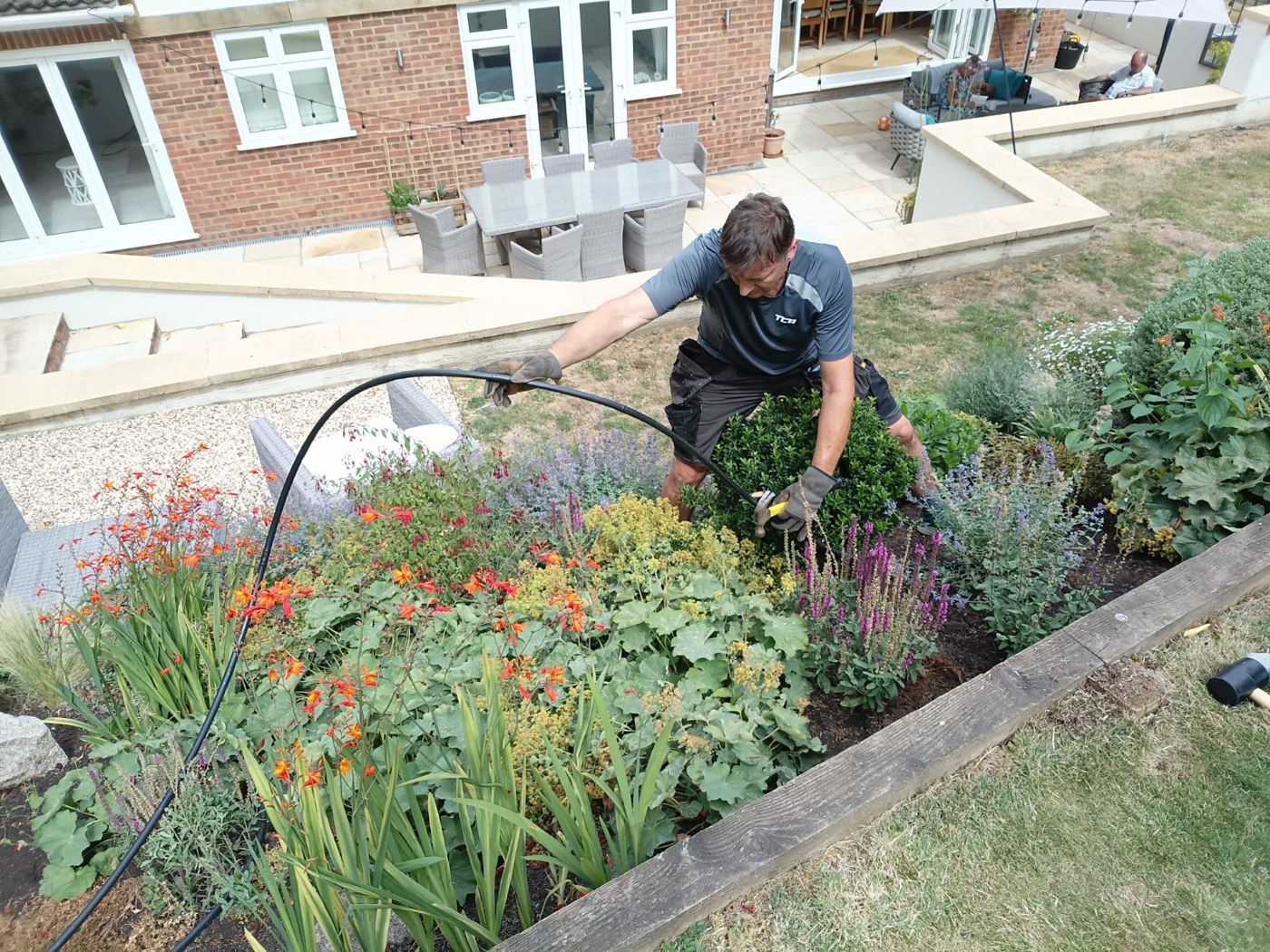Installing irrigation in a colourful sloping garden
