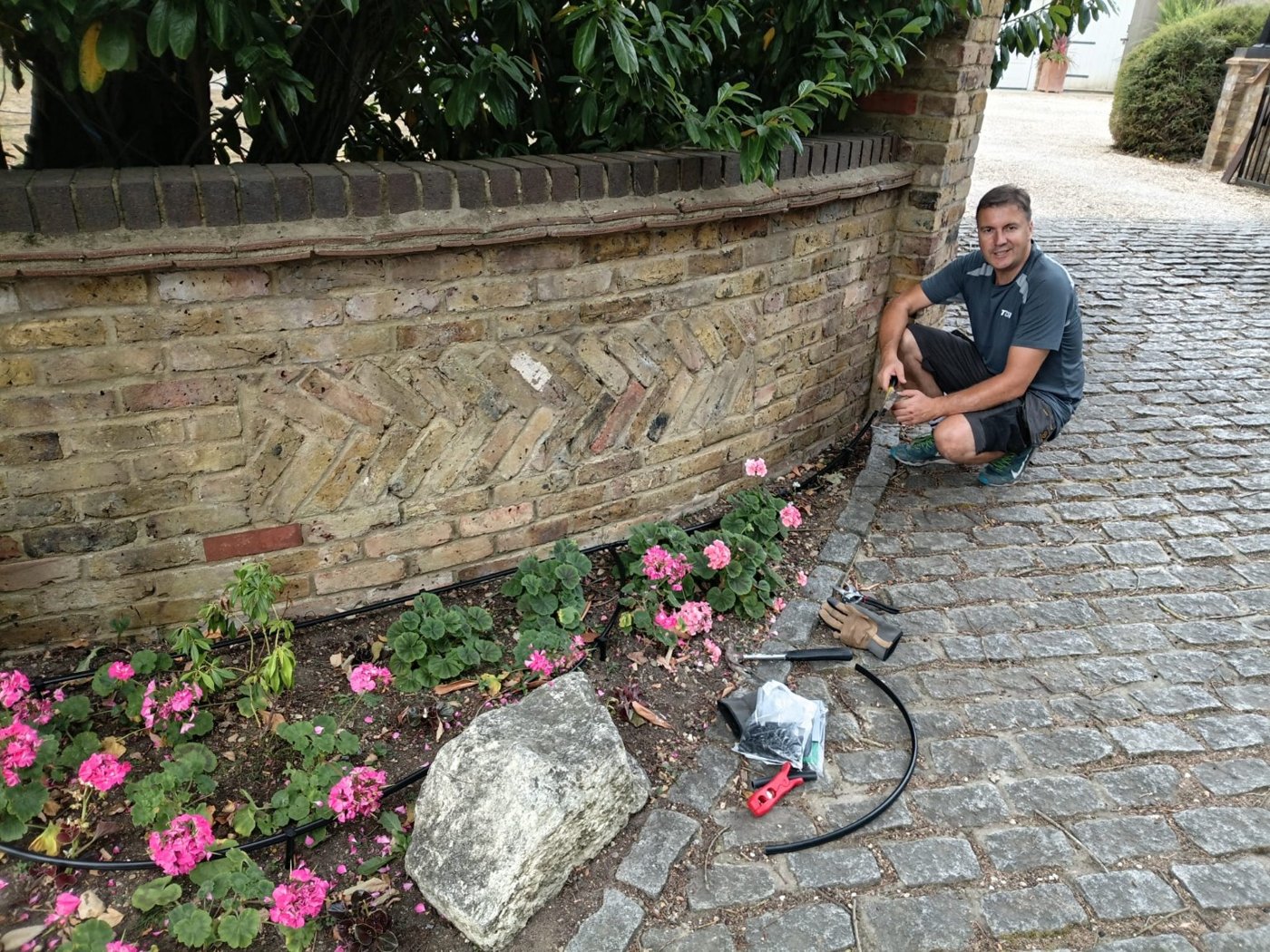 Working on a flower bed beside a brick wall